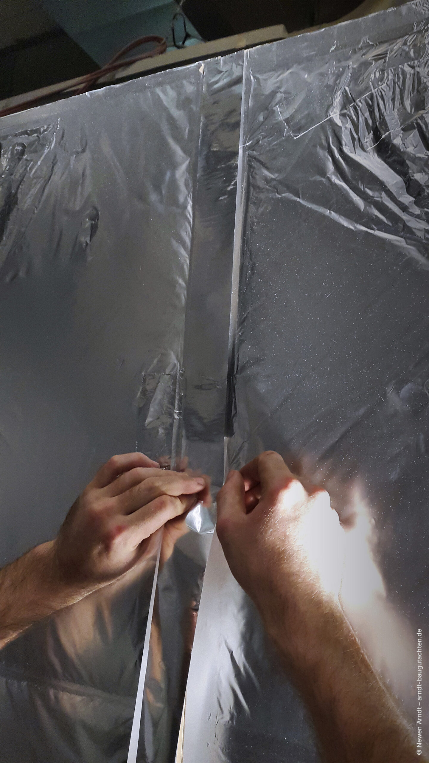 Bild 01 - Newen Arndt, Luftdichtfolie Verklebung Sauna Wellness Sorgfältige luftdichte Verklebung einer Folienlage bei der Errichtung einer Saunakabine