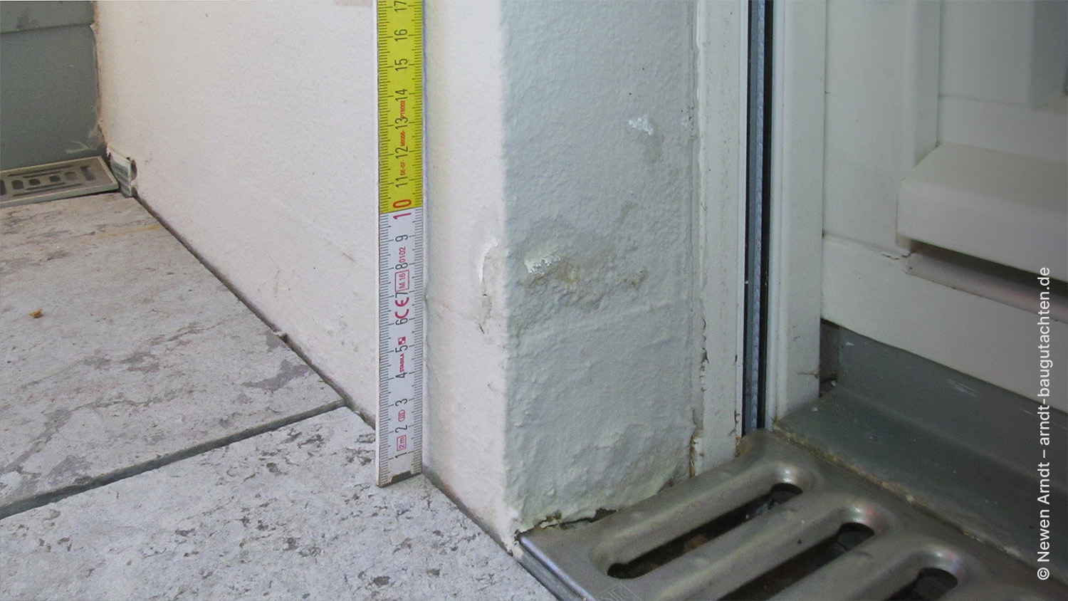 Bild 03 - Newen Arndt, Fassade Sockel feuchte bedingt Schaden Neubau Feuchtebedingter Sockelschaden an einem Neubau (Bildmitte)